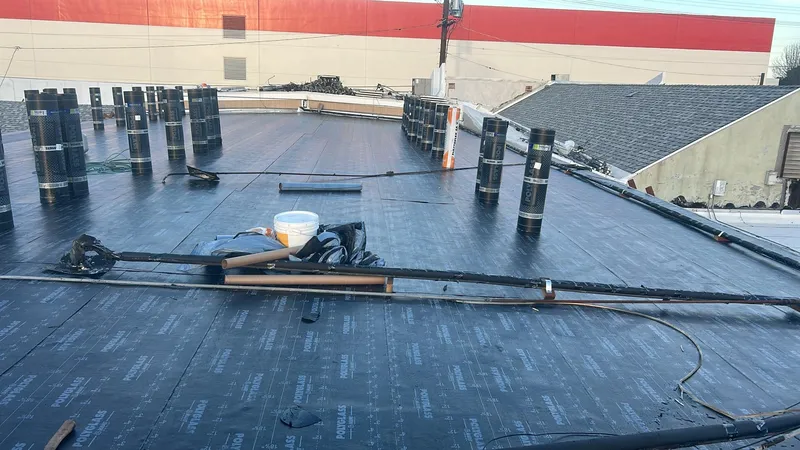 Low-slope roof work detail with rolled roofing material