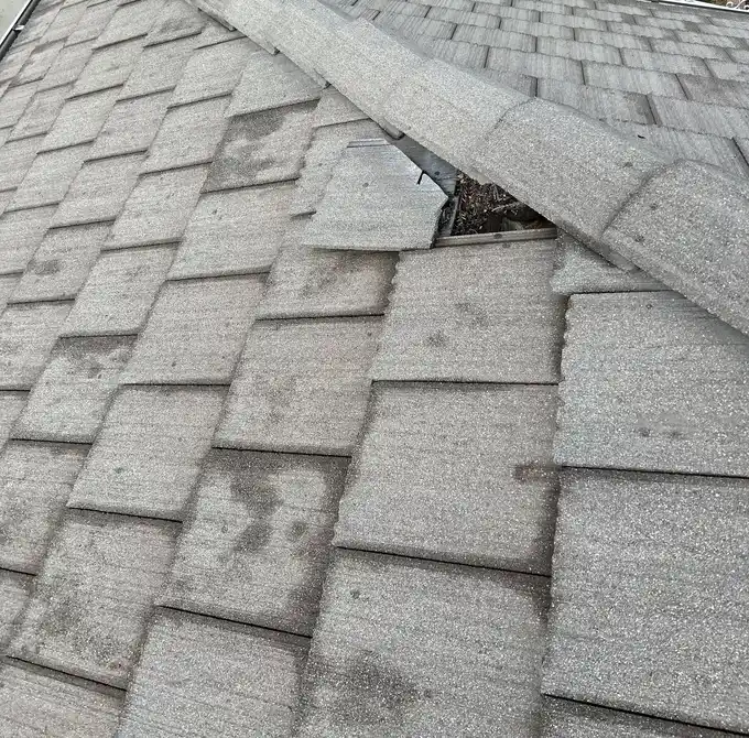 Weathered shingles around an exposed ridge section
