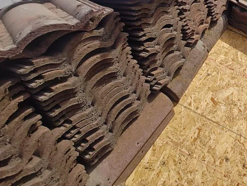 Removed roof tiles stacked on wood decking